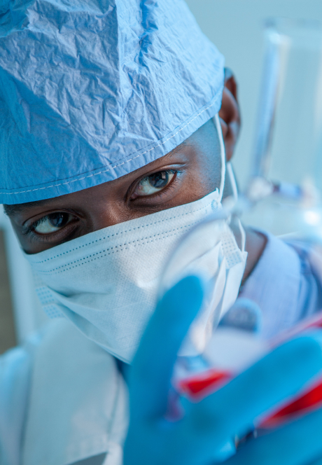 Young black man in a lab examining at test tube