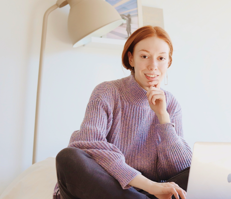 Woman sitting with her leg crossed with a laptop in front of her