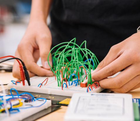 close up of hands working on an electronic project