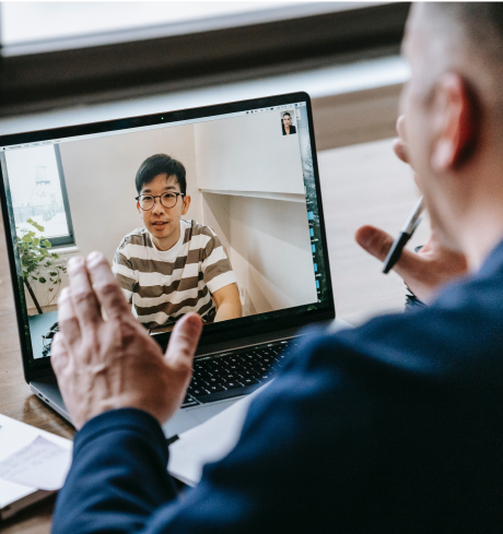 Professor speaking with university student by video conferance on his laptop