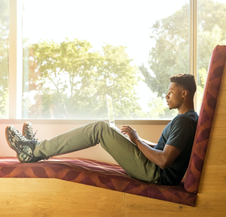 Man laying down with his laptop on his lap