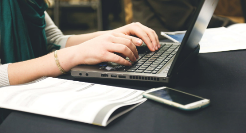 Close up of a person's hands typing on a keyboard