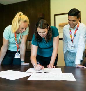 group of people looking down on table at papers