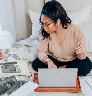 female looking at photo while on laptop