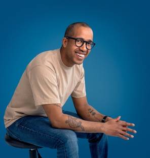 Image of man sitting on chair in front of blue background