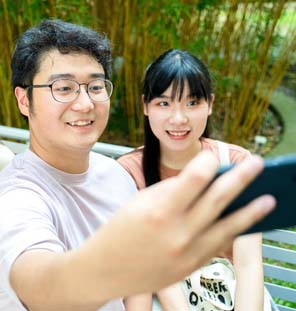 woman and man holding phone camera to take a photo