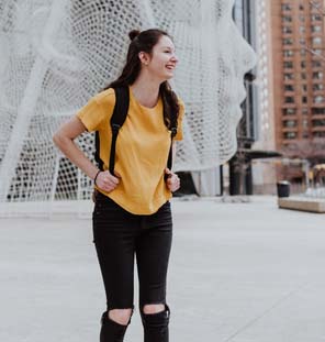 female carrying backpack and laughing