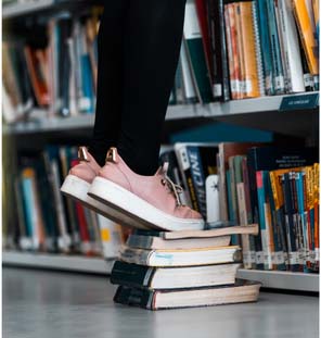 Person standing on top of books