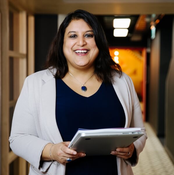 Woman smiling holding a notepad