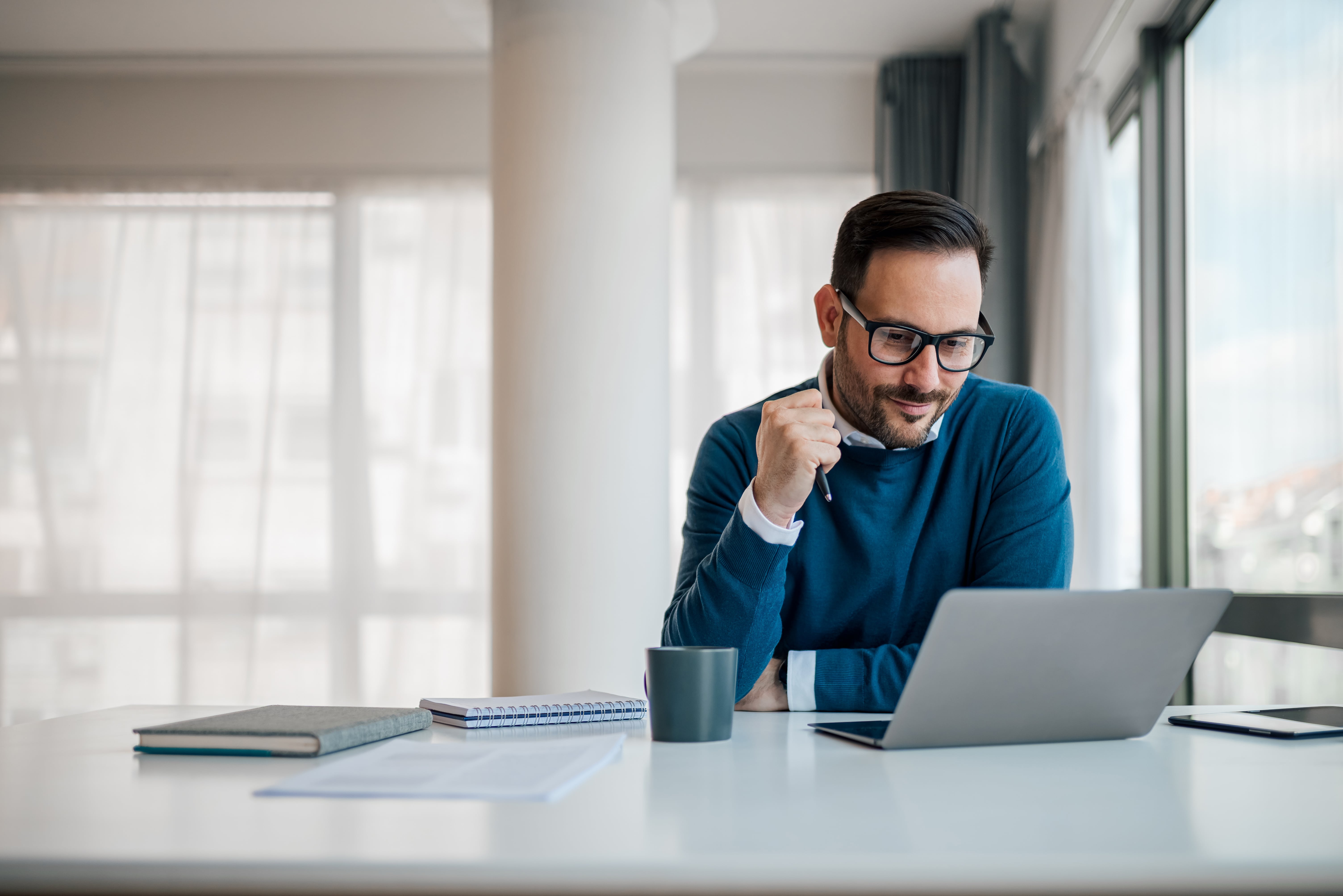 businessman sitting at desk using laptop focused on work