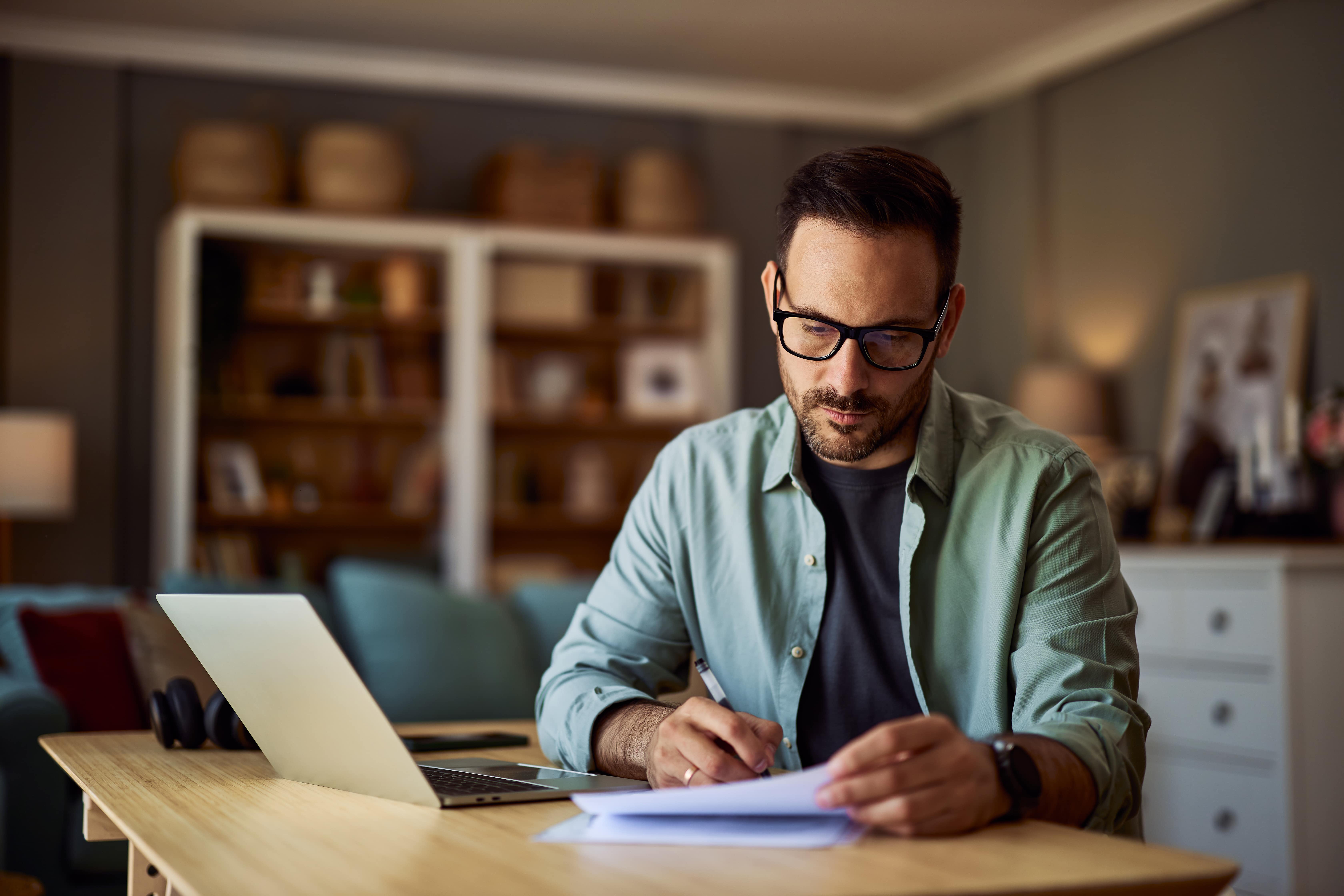 man sitting at desk reading over papers