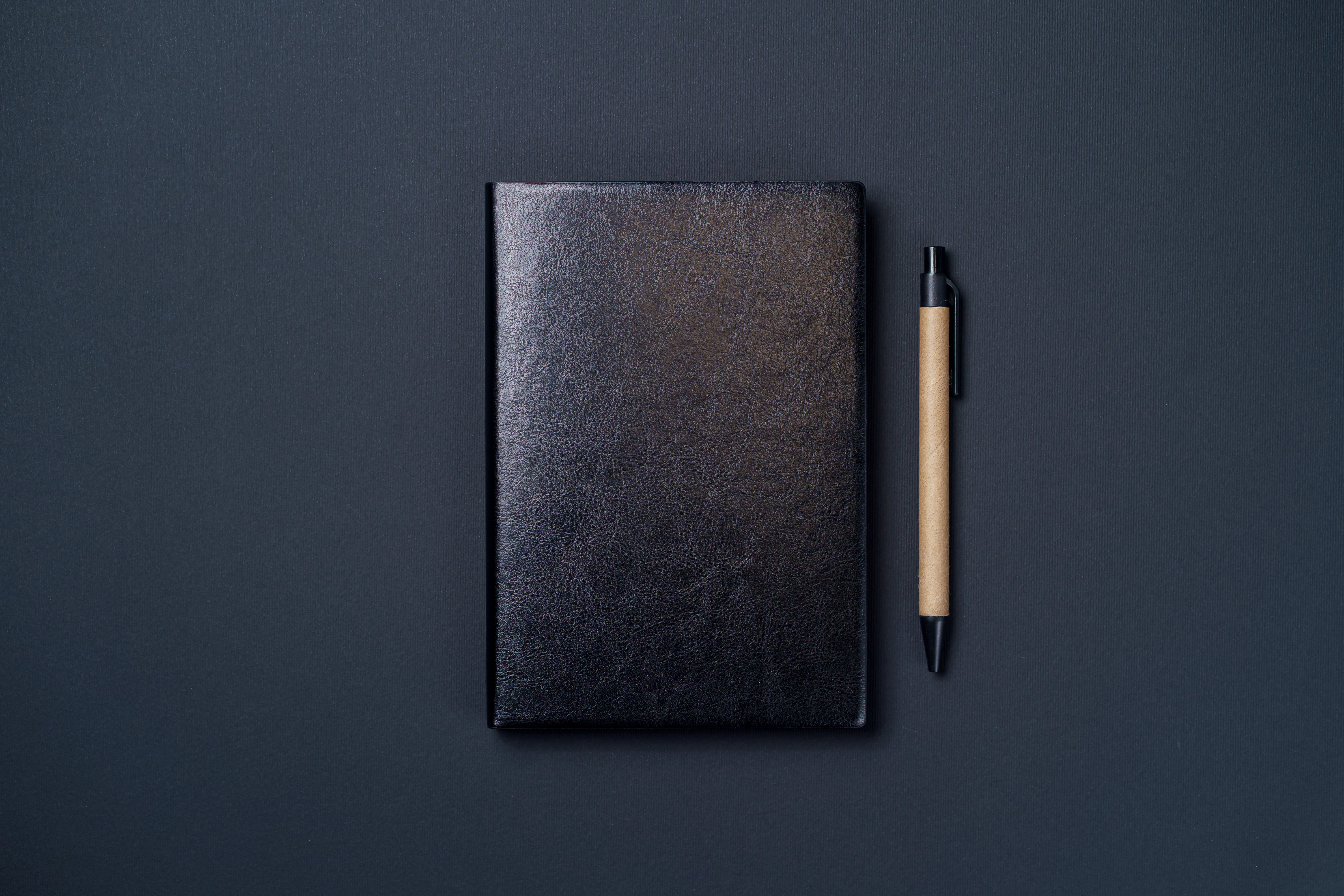 black notebook and writing pen