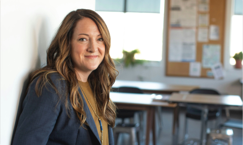 woman posing for camera smiling with classroom in background