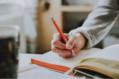 Close up of a person's hand writing in a journal