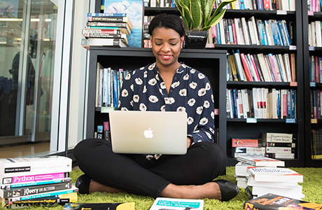 woman sitting on the floor with books all around her