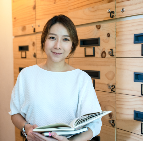Female professional smiling and holding an open course book.