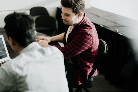 Two men in a meeting room discussing work culture