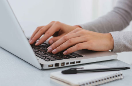 hands typing on a laptop keyboard