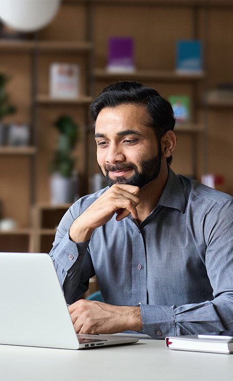 Man sitting at a desk working on a laptop