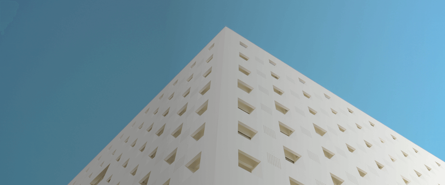 Blue sky and white business building with many windows. 
