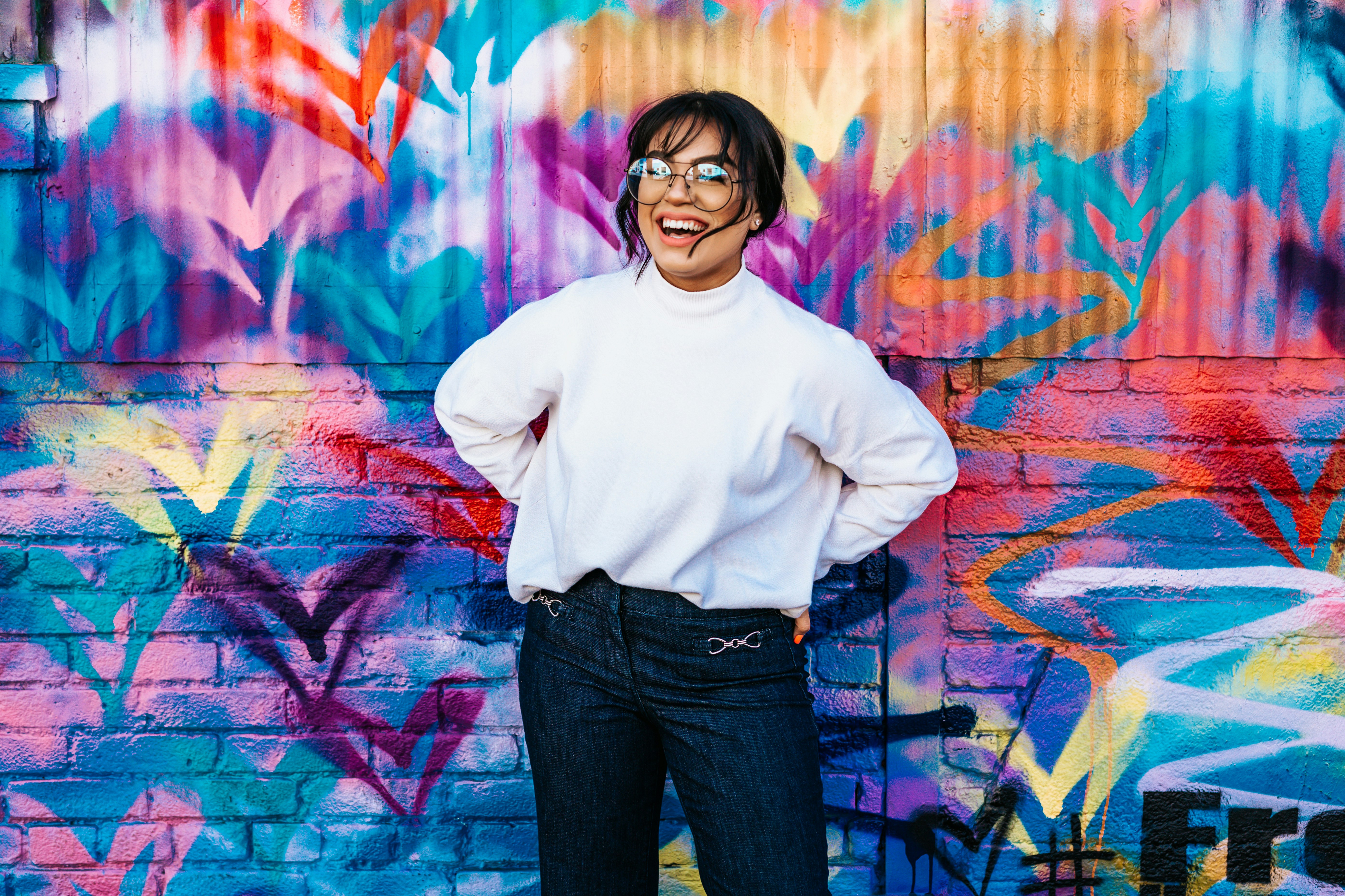 woman posing for camera smiling with bright art background